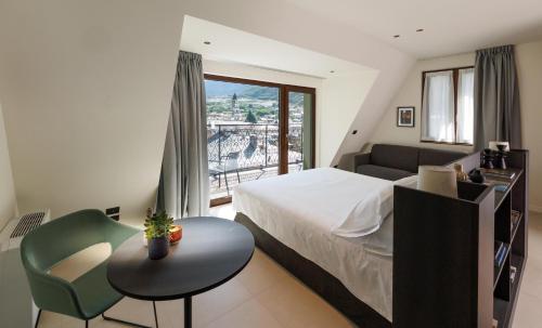a bedroom with a bed and a table and a couch at Hotel Stelvio Tirano in Tirano