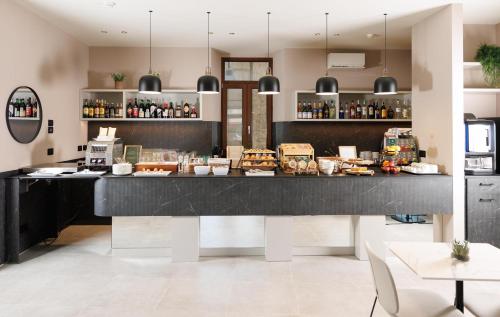 a restaurant with a counter with food and drinks at Hotel Stelvio Tirano in Tirano