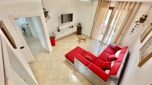 an overhead view of a living room with a red couch at A1 Fiori di Pesco #TRILOCALE DOPPI SERVIZI- Fiera Rho Milano Monza Como Malpensa in Cesate