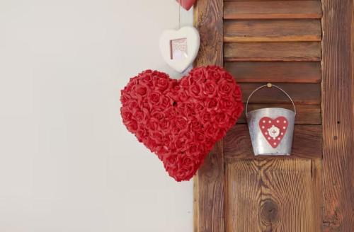 a bunch of red hearts hanging on a wall at B&B Ca' La Vedescia in Teglio