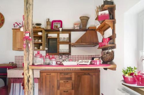a kitchen with wooden cabinets and pink counter tops at B&B Ca' La Vedescia in Teglio