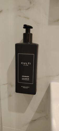 a black bottle of soap sitting on a counter at Hotel Margot in Milan