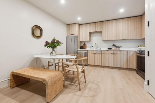 a kitchen with wooden cabinets and a table and chairs at Casa Riviera - Boutique Apartments in Downtown Santa Barbara in Santa Barbara