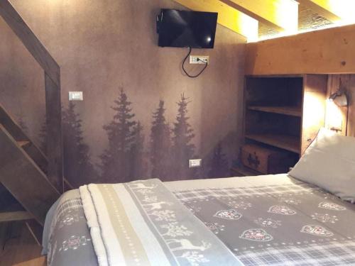 a bedroom with a bed with a painting of trees at B&B Ca' La Vedescia in Teglio