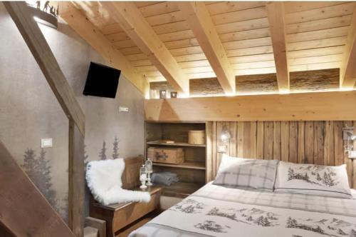 a bedroom with a bed and a wooden ceiling at B&B Ca' La Vedescia in Teglio