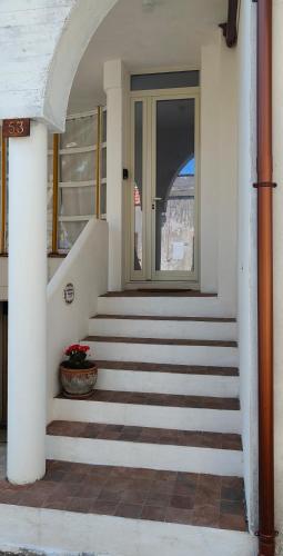 a house with stairs and a door with a plant at La dimora di Lorenzo in Giurdignano