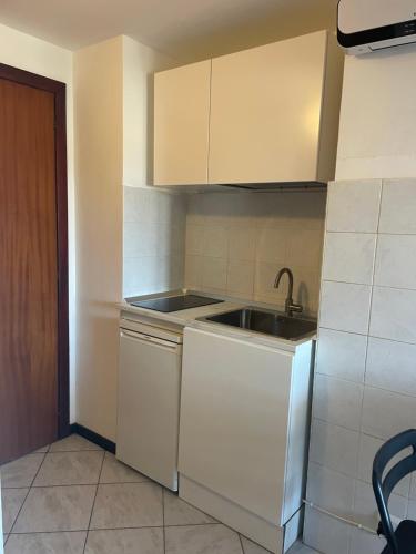 a kitchen with white cabinets and a sink and a stove at Mansarda N12 Galliari in Turin