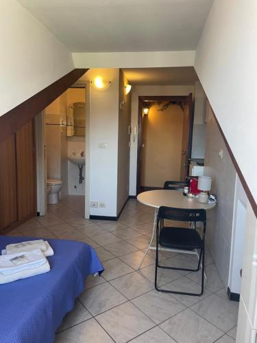 a room with a bed and a table and a bathroom at Mansarda N12 Galliari in Turin