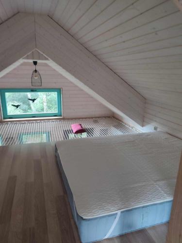 una cama grande en una habitación con ventana en Węgiełek Treehouse Little Barn, en Kazimierz Dolny