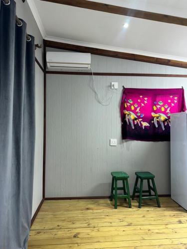 two green stools in a room with a pink blanket at Signal hill estate in Ponta do Ouro