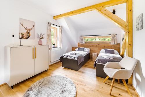 a bedroom with two beds and a table and a chair at Šumavské Hájenky - Lipno in Horní Planá