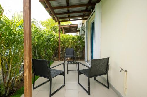 a patio with chairs and a table on a house at Luxury cozy Apartment in Koolbaai