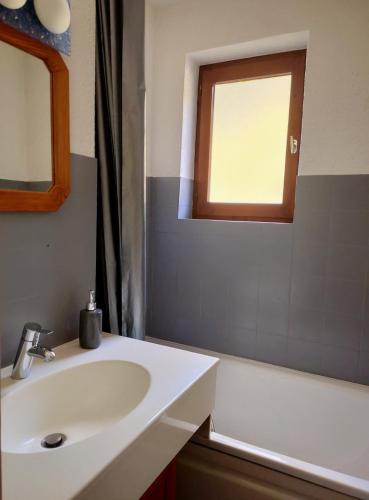 a bathroom with a sink and a tub and a window at Studio Châtel Secteur Linga Proche Pistes in Châtel