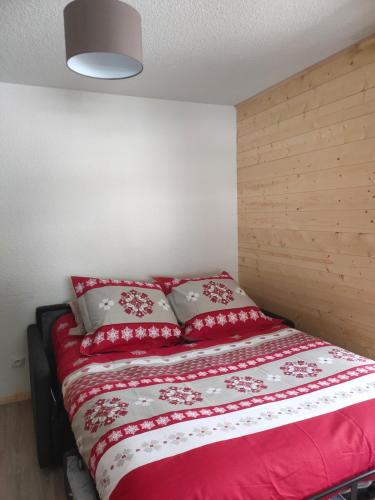 a bedroom with a bed with red sheets and pillows at Studio Châtel Secteur Linga Proche Pistes in Châtel