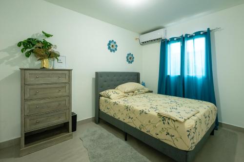 a bedroom with a bed and a dresser at Luxury cozy Apartment in Koolbaai