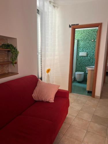 a red couch in a living room with a bathroom at MARCONI APARTMENTS in Termoli