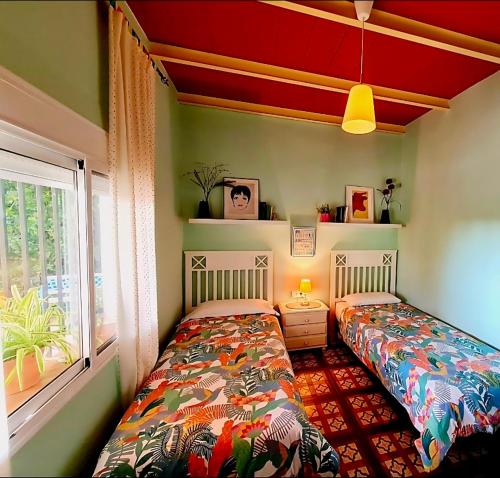 a bedroom with two beds and a window at Villa Mirador del Sol, 45min playas de Doñana, 35min de Sevilla in Villalba del Alcor