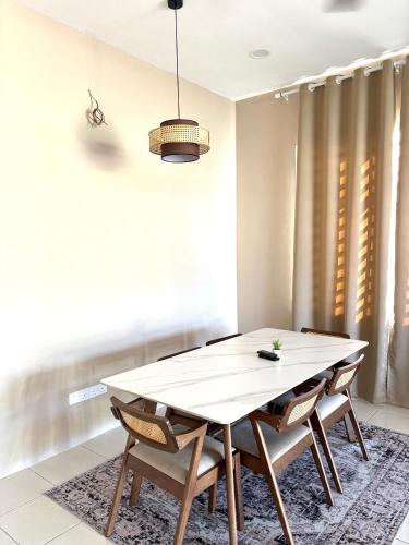 a dining room with a white table and chairs at House at Pantai Sepat 2BR Netflix Coway in Kuantan