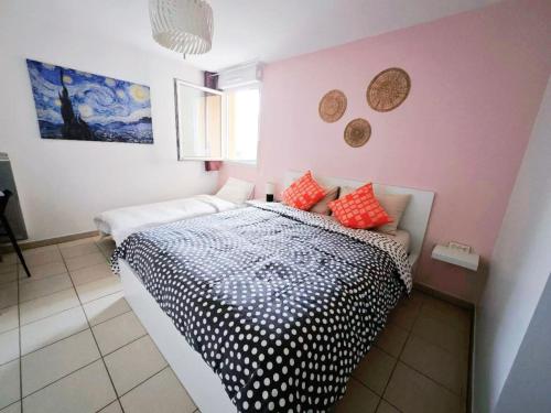 a bedroom with a black and white bed with red pillows at Proche Disney Paris Appartement cosy et familial pour 4 Pers-Wifi-Parking Privé in Bussy-Saint-Georges