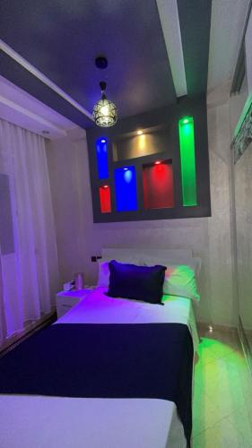 a bedroom with a bed with colorful lights on it at Tru Home suites in El Jadida