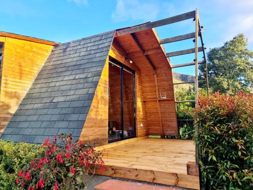 a house with a wooden deck in a garden at Cabañas Altos del Dorado in Guatavita