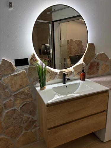 een badkamer met een wastafel en een spiegel bij Padul Suites Apartamentos in Padul