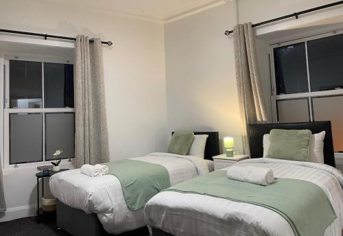 EdenderryにあるBudget Roomsの窓が2つある部屋にベッドが2つある