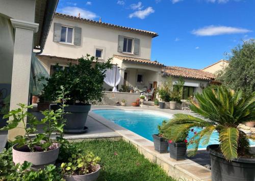 a villa with a swimming pool in front of a house at Une Amazone en Povence in Paradou
