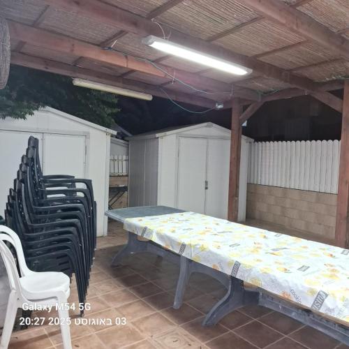 a table and chairs in a patio with a table and a table and chairs at אירוח על הים in Ashqelon