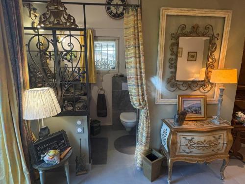 a bathroom with a toilet and a mirror and a table at Une Amazone en Povence in Paradou