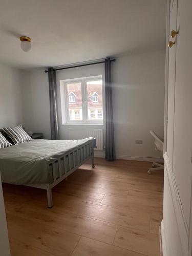 a bedroom with a bed and a large window at La CAZA Guest House in Royston