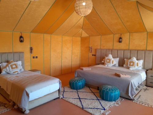 1 dormitorio con 2 camas en una tienda de campaña en TRIP Merzouga luxury camp, en Adrouine