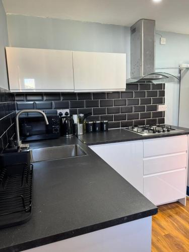 a kitchen with a sink and a microwave at Newly built studio apartment in Manchester