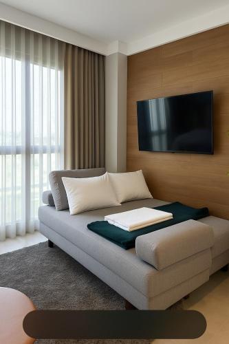 a living room with a couch with a flat screen tv at Flat Praia Luxury Century in Vitória