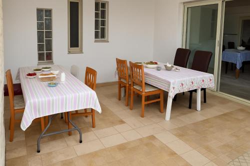 a dining room with two tables and chairs with food on them at La dimora di Lorenzo in Giurdignano