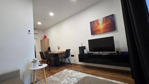 a living room with a television and a table with chairs at Apartment Lovro in Ivanec