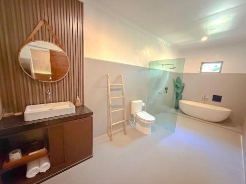 a bathroom with a sink and a toilet and a mirror at Kelingking Tropical in batumadeg