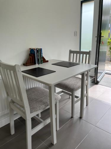 a white table and chairs with books on it at Cille Apartments, Ballyferriter village in Ballyferriter