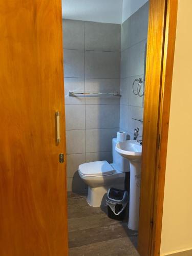a bathroom with a toilet and a sink at MH Hostel in Encarnación