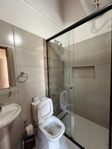 a bathroom with a toilet and a shower and a sink at MH Hostel in Encarnación