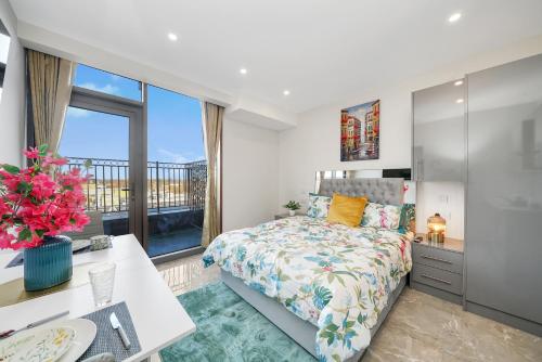 a bedroom with a bed and a desk and a window at Studio with Balcony Godino Hotel Ilford in Ilford