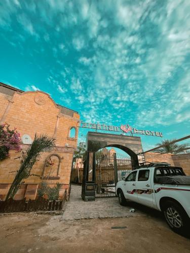a white car parked in front of a gate at Tarakhan Hotel in Dahab
