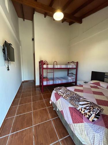 a bedroom with two bunk beds and a television at MH Hostel in Encarnación