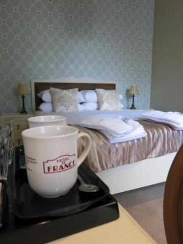 Katil atau katil-katil dalam bilik di Logis Hotel De France