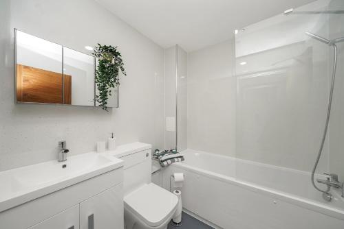 a white bathroom with a toilet and a sink at Studio with Balcony Godino Hotel Ilford in Ilford