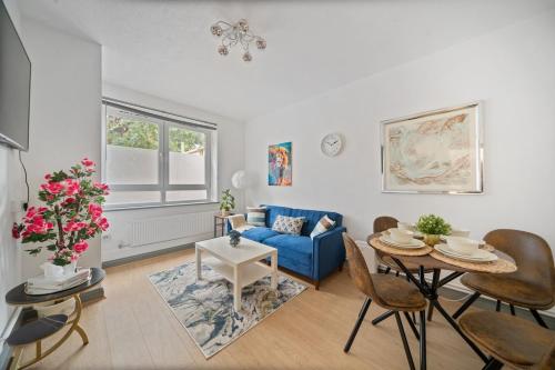 a living room with a blue couch and a table at Moro Luxe Homes in London