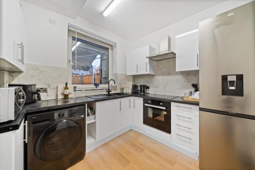 a kitchen with white cabinets and a stainless steel appliance at Moro Luxe Homes in London