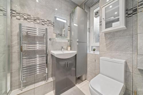 a white bathroom with a sink and a toilet at Moro Luxe Homes in London