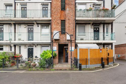 an apartment building with an orange gate and a door at Moro Luxe Homes in London