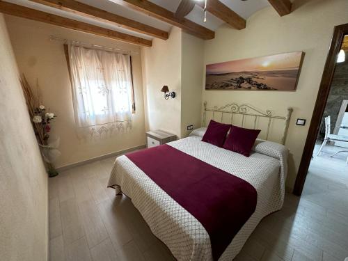 a bedroom with a large bed with purple pillows at Alojamientos Rurales La Higuerilla Sierra de Cazorla in Burunchel